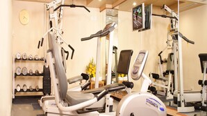 A gym with cardio equipment, dumbbells, and a mirror. - Aditya Park Hyderabad (Hyderabad)