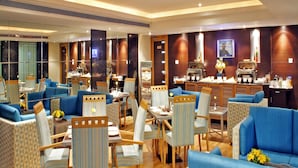 A spacious hotel lobby with multiple seating areas, a coffee station, and a television screen. - Aditya Park Hyderabad (Hyderabad)