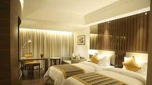 A hotel room with two beds, a desk, a chair, and a small table. - Aditya Park Hyderabad (Hyderabad)