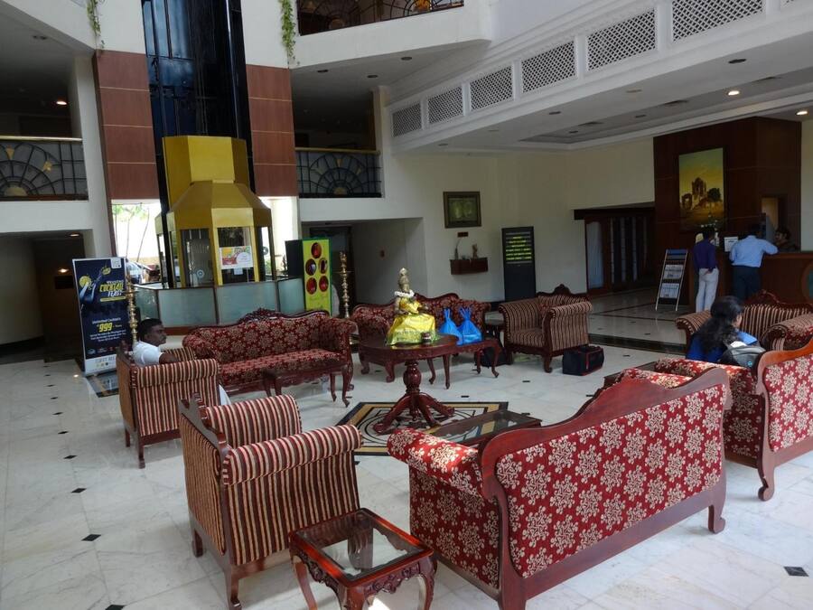 Un'ampia hall con diverse zone relax, una reception e una statua decorativa.