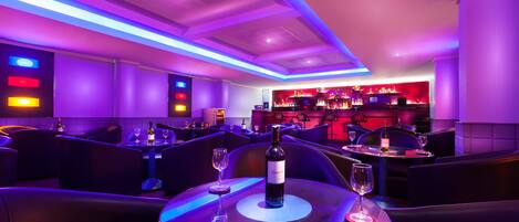 A modern bar area with seating and a bar counter.