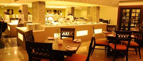 Un restaurant avec un comptoir central, plusieurs tables et des chaises.