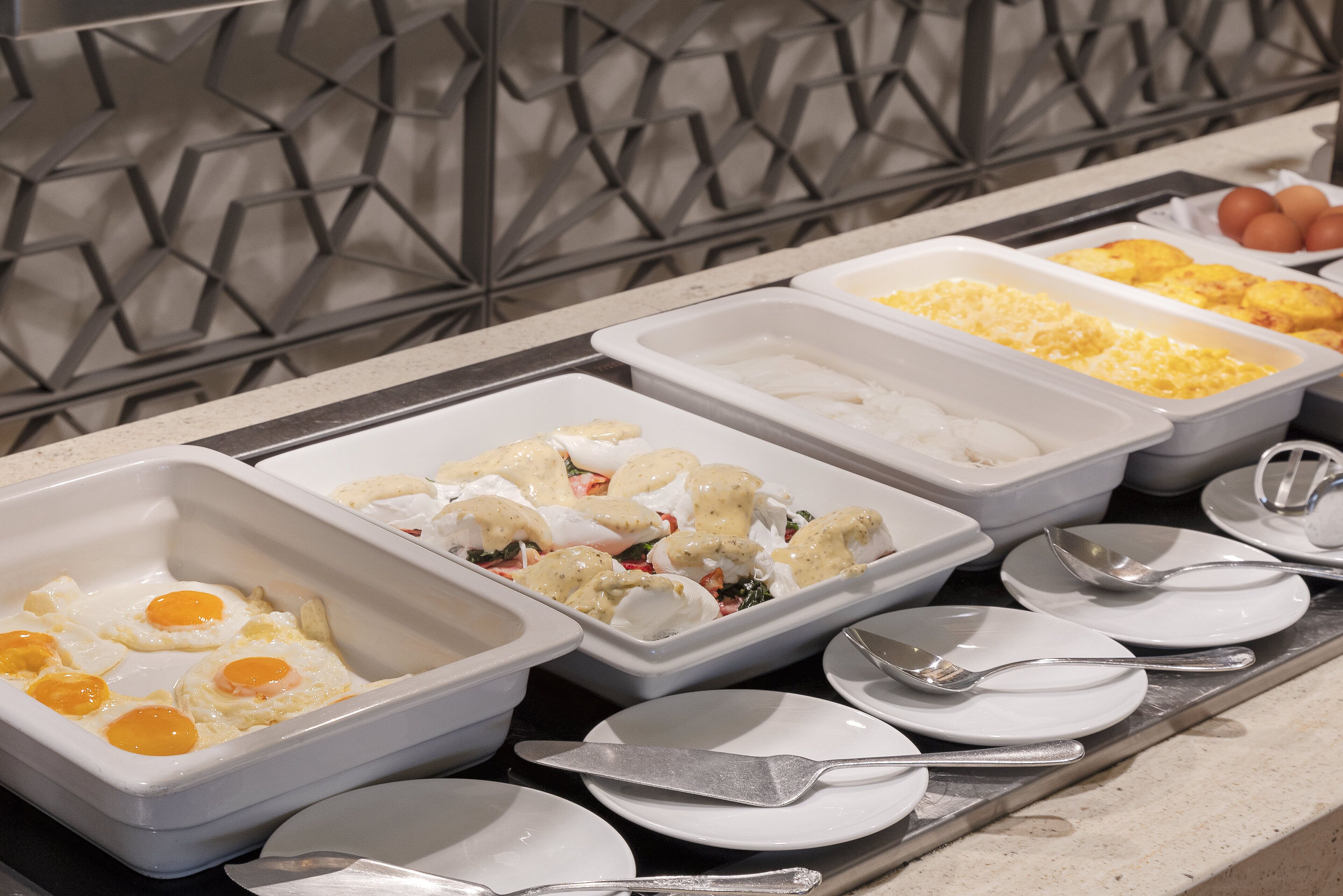 Een buffet met diverse gerechten, waaronder eieren, omeletten en meer.