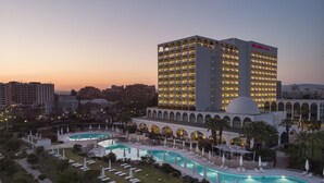 Un hotel con varias piscinas, una piscina central grande y una estructura en forma de cúpula.