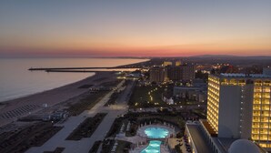 Un resort con piscina, playa y vista a la playa.
