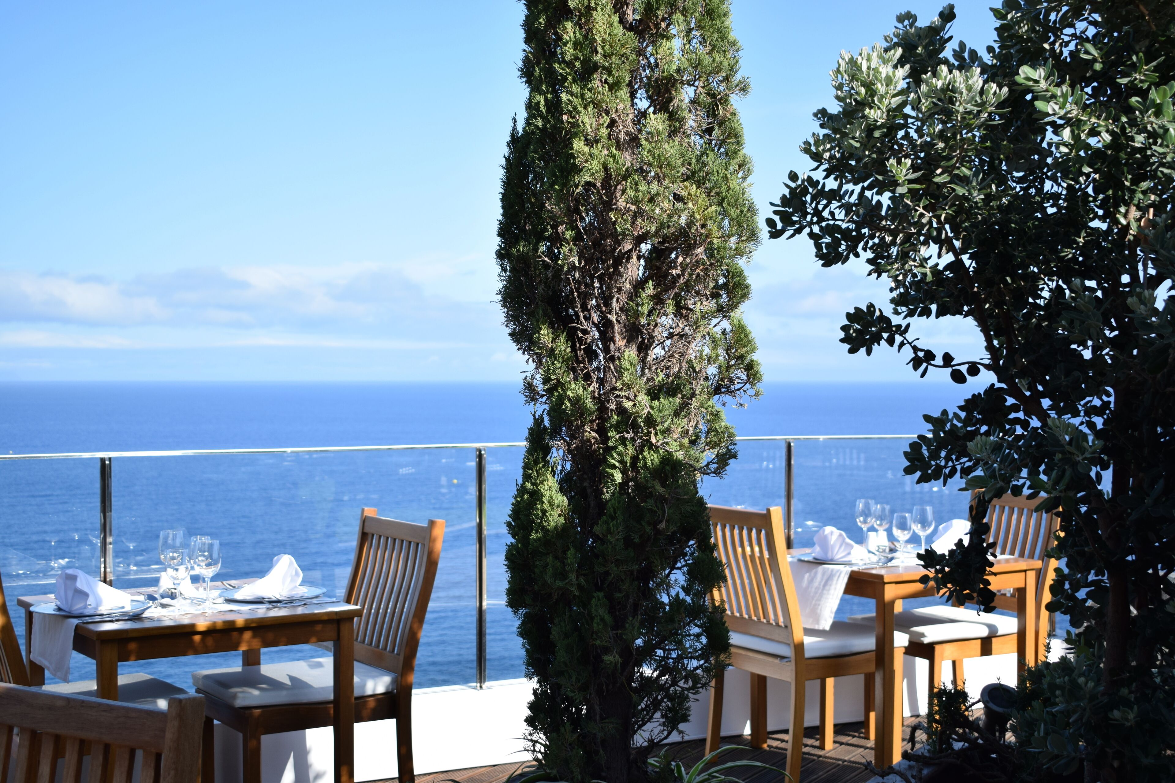 A dining area with a table set for two, overlooking the sea.