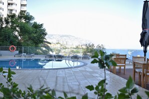 Piscine couverte, piscine extérieure, parasols de plage, chaises longues