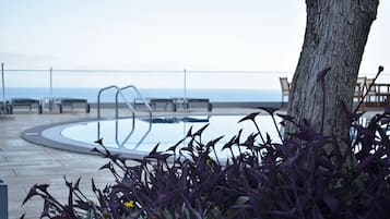 Piscine couverte, piscine extérieure, parasols de plage, chaises longues