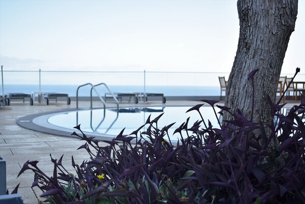 Piscine couverte, piscine extérieure, parasols de plage, chaises longues