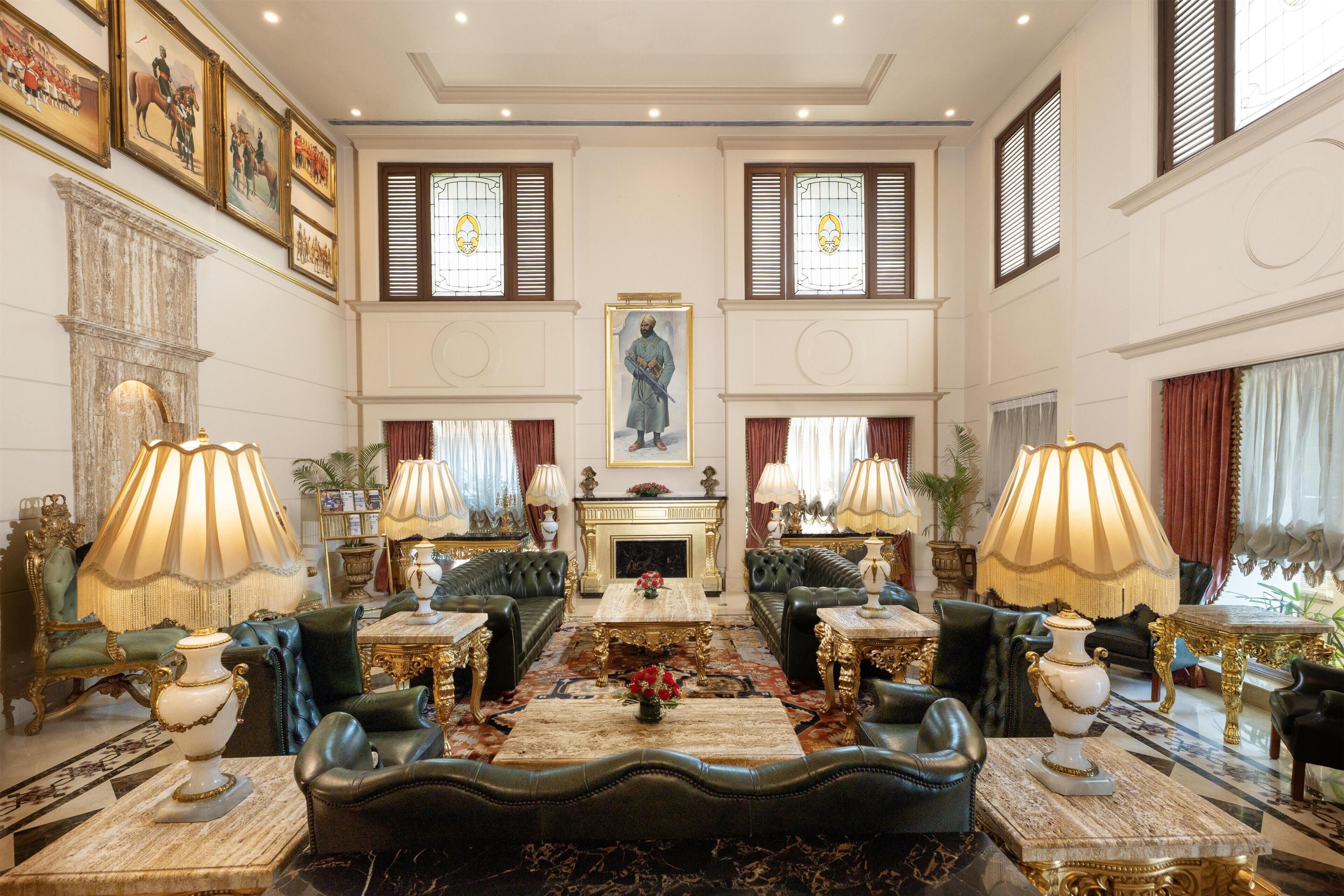 Um quarto luxuoso com uma lareira grande, mobiliário requintado e quadros históricos emoldurados.