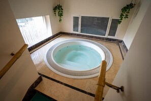 A hot tub in a corner with a view of the outside. - Radisson Hotel Jalandhar Grand Windsor Resorts Ltd (Jalandhar)