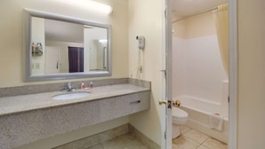 Une salle de bain avec un lavabo, un miroir et un espace douche.