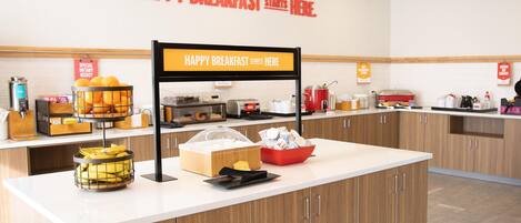 A breakfast station with a sign that reads 'HAPPY BREAKFAST STARTS HERE.'