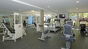 A gym with various exercise machines, a treadmill, and a stationary bike. - Oakwood River Oaks North (Rochester)