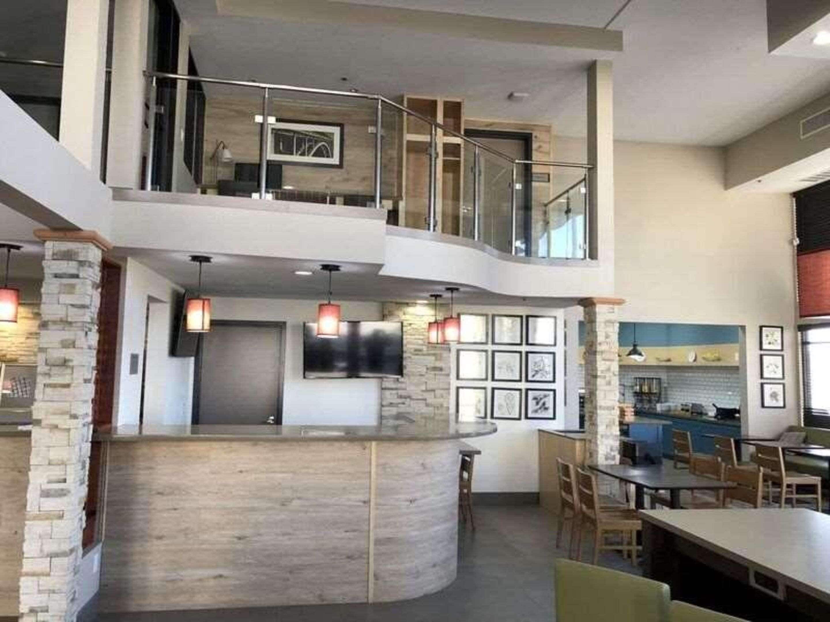 Un interior amplio con una encimera curva, zona de estar y cocina a la vista.