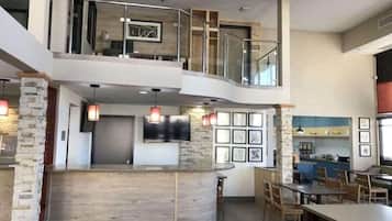 Un interior amplio con una encimera curva, zona de estar y cocina a la vista.