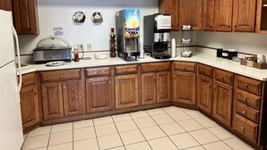 Una cocina con armarios de madera, una cafetera y un microondas.