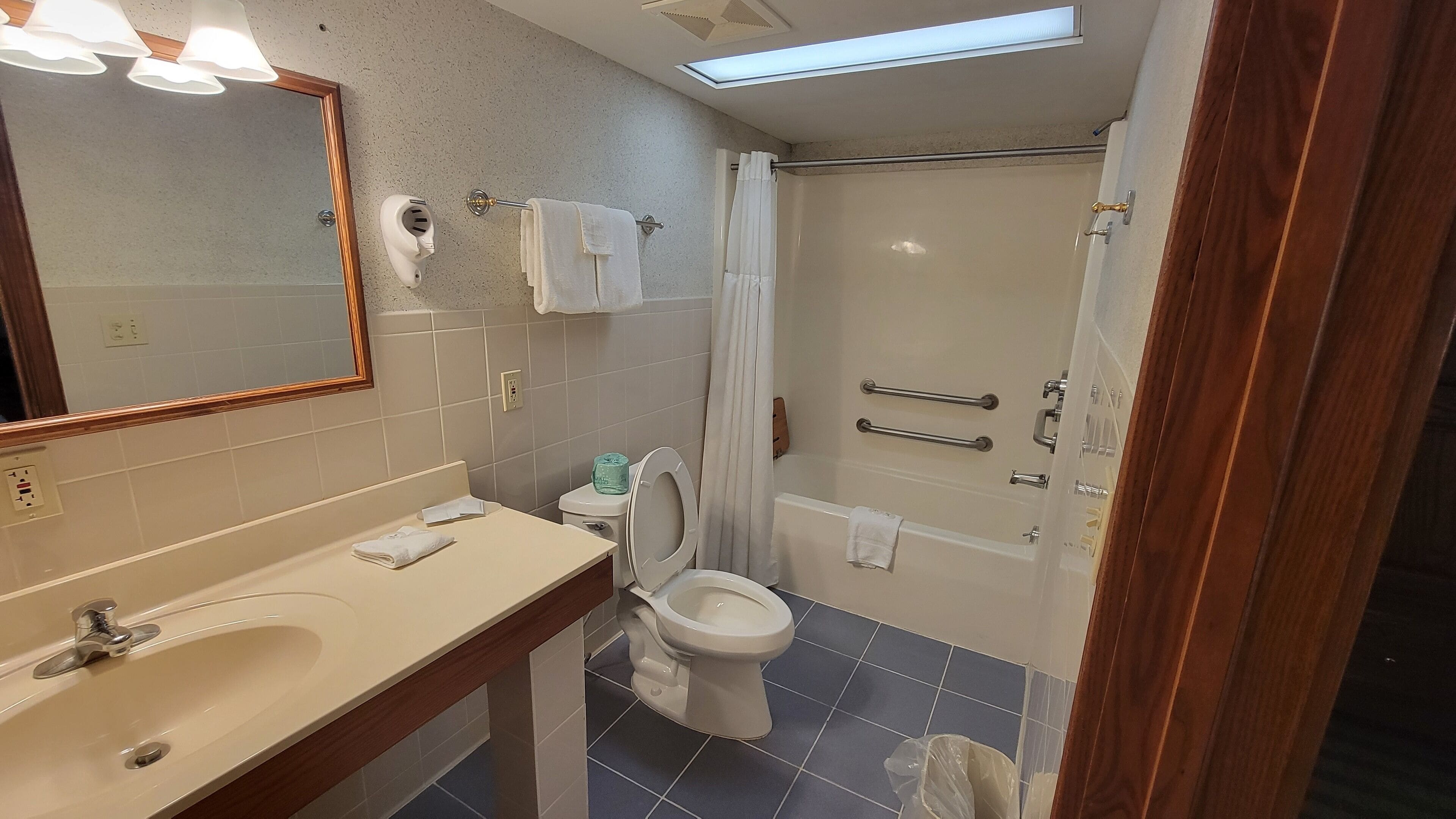 A bathroom with a sink, toilet, and shower.