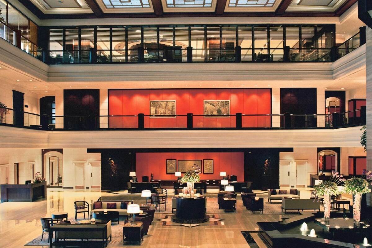 A spacious lobby with a high ceiling, multiple seating areas, and a central fountain.