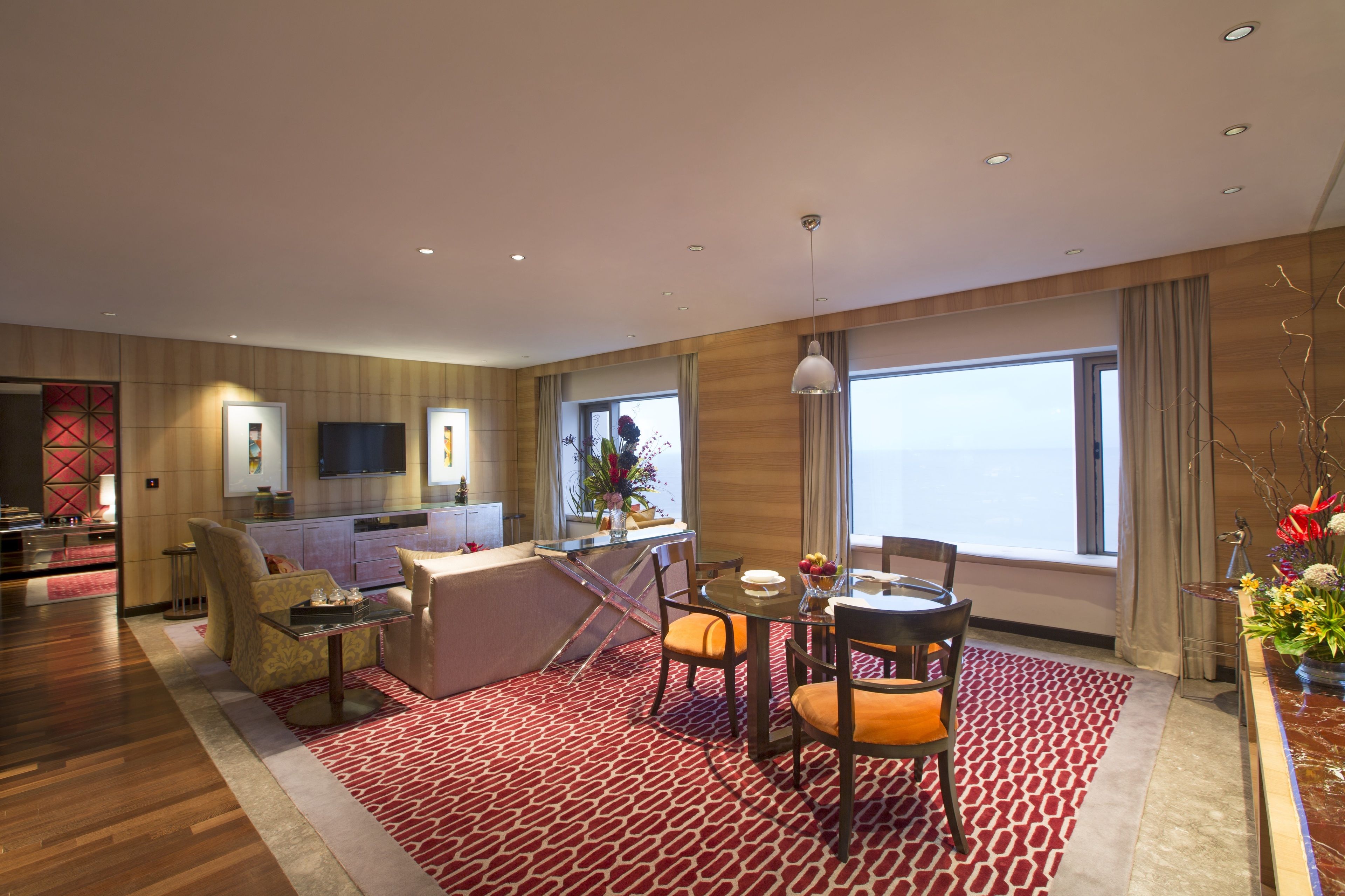 Una habitación de hotel moderna con comedor, cocina y un ventanal con vistas.