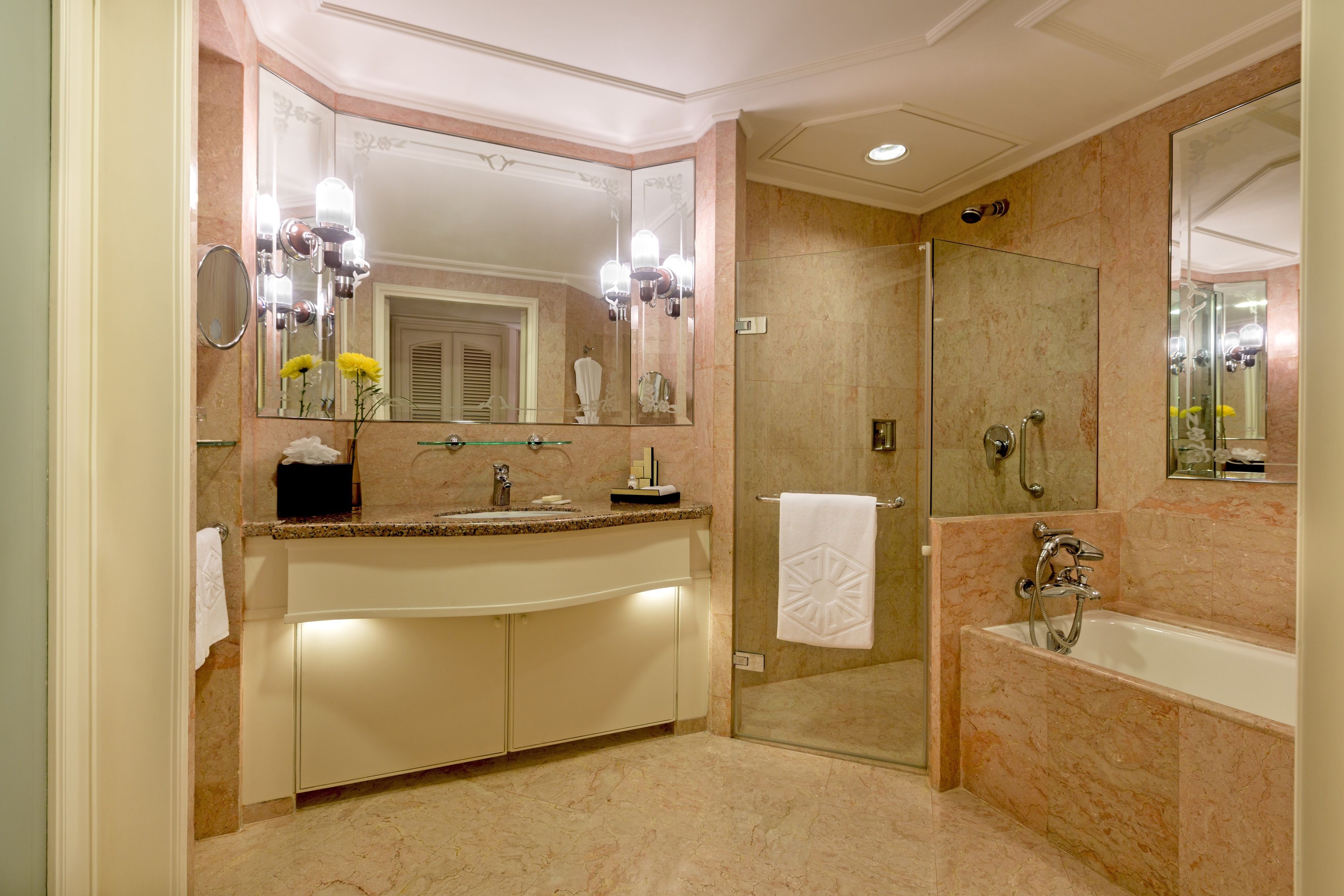 Un baño moderno con ducha envuelta en vidrio, un espejo grande y una bañera.