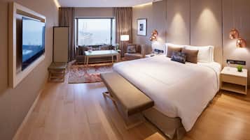 Quarto de hotel moderno com uma cama grande, uma escrivaninha e vista para uma ponte.