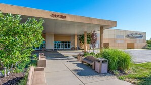 A modern building with a beige facade, a large entrance, and a sign reading "1730".