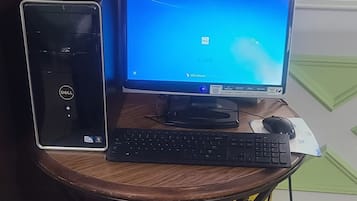 Ein Computerarbeitsplatz mit einem Desktop-Tower, Monitor, Tastatur und Maus auf einem Holztisch.