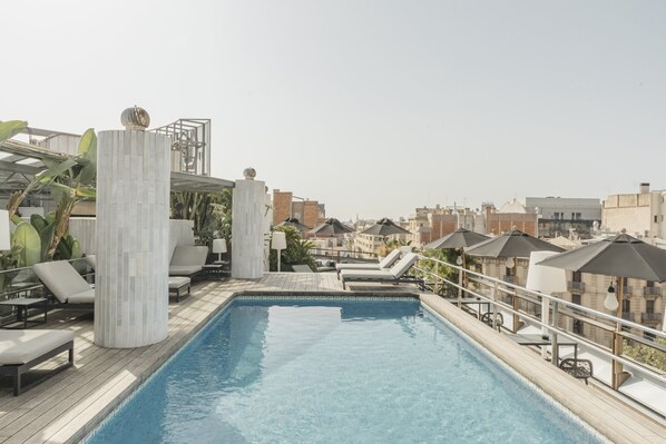 A rooftop pool with lounge chairs and umbrellas, surrounded by buildings. - Claris Hotel & Spa 5*GL, a Small Luxury Hotels of the World (Barcelona)