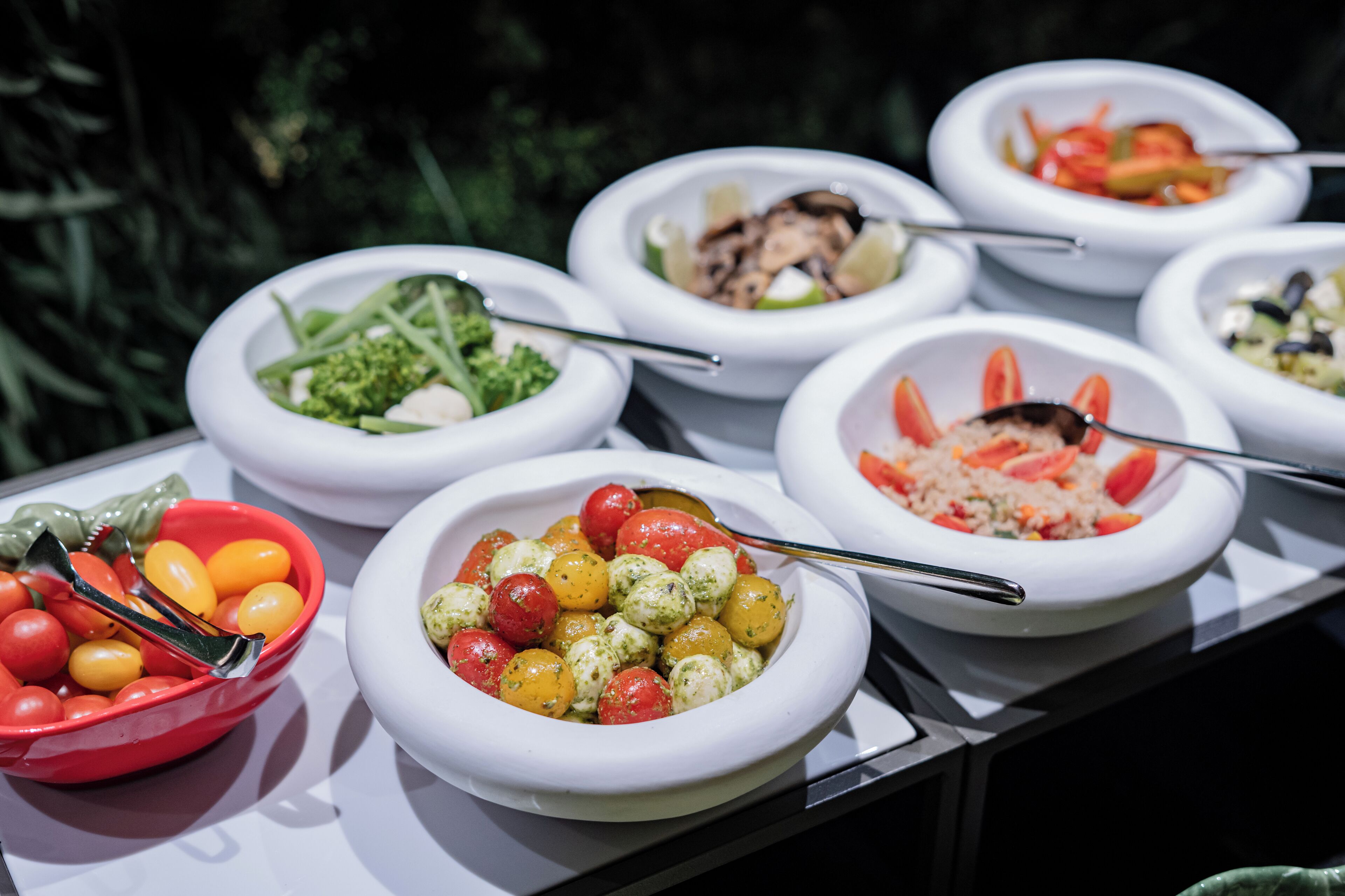 A variety of dishes in white bowls on a table.