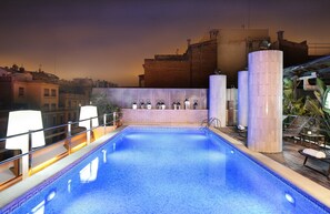 Relax by the pool with lounge chairs and a clear view of the surrounding buildings.