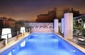 Relax by the pool with lounge chairs and a clear view of the surrounding buildings.