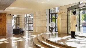 A spacious lobby with a curved staircase, a reception desk, and a large decorative vase. - Claris Hotel & Spa 5*GL, a Small Luxury Hotels of the World (Barcelona)