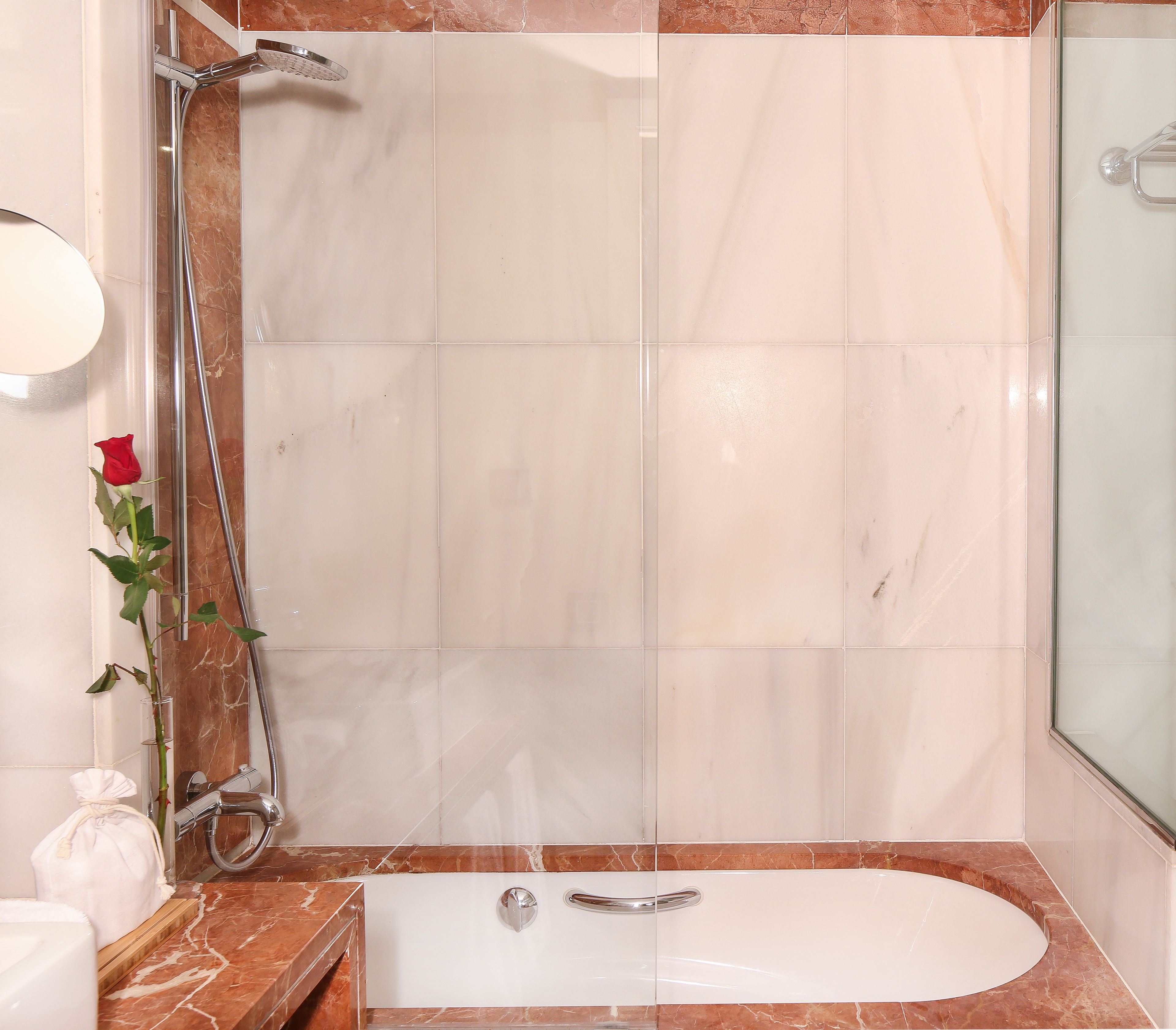 Un baño con ducha, bañera y encimera de mármol.