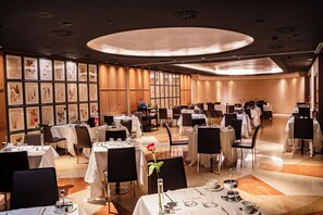 A spacious restaurant with multiple tables and chairs, framed botanical artwork on the walls, and a modern ceiling design. - Claris Hotel & Spa 5*GL, a Small Luxury Hotels of the World (Barcelona)