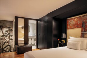Relax in a spacious room with a large bed, dark wardrobe, and a cozy seating area.
