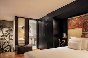 Relax in a spacious room with a large bed, dark wardrobe, and a cozy seating area.