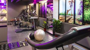 A gym with exercise equipment, a treadmill, and a wall with a running image.