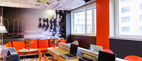 Un espacio de oficina moderno con un mural grande de un tablero de ajedrez, una computadora portátil y un escritorio con una silla.