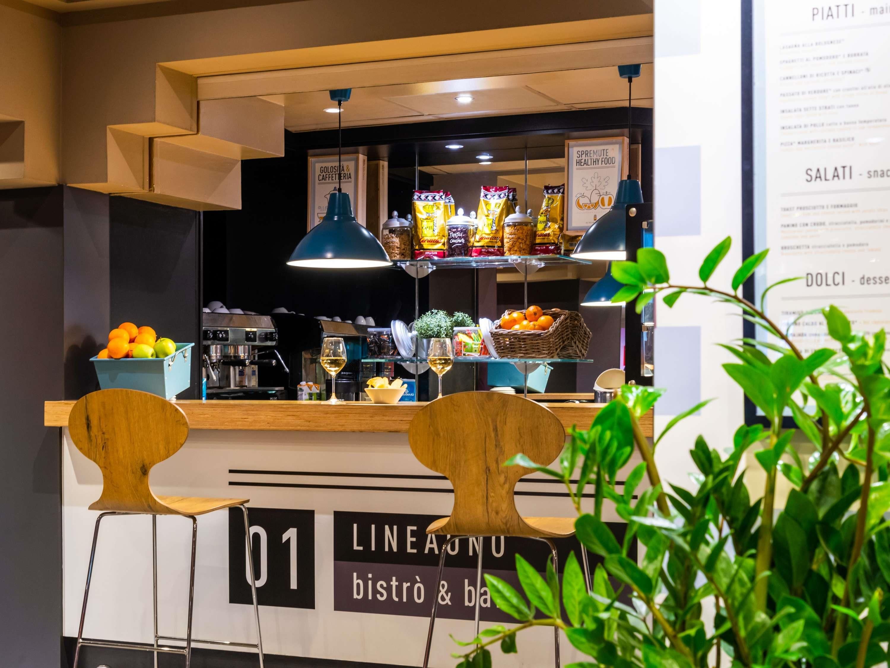 A bistro with a counter, chairs, and a menu board.