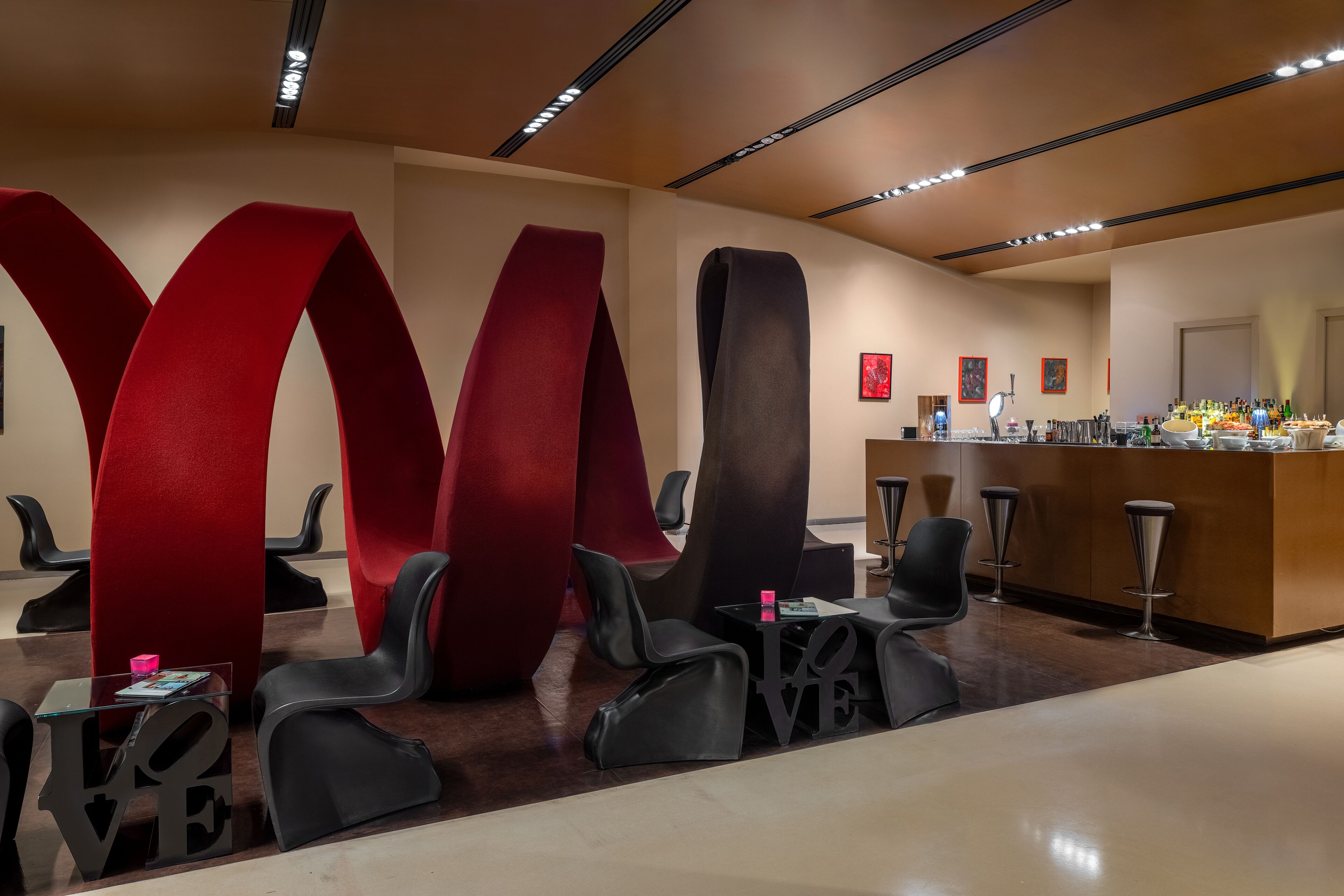 A modern reception area with a bar, seating, and large abstract wall art.