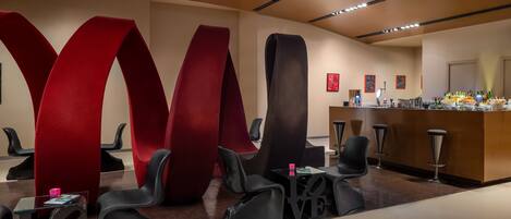 A modern reception area with a bar, seating, and large abstract wall art.