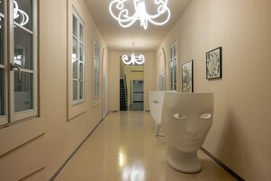 Un corridoio dal design moderno, con una scultura bianca e opere d'arte incorniciate alle pareti.