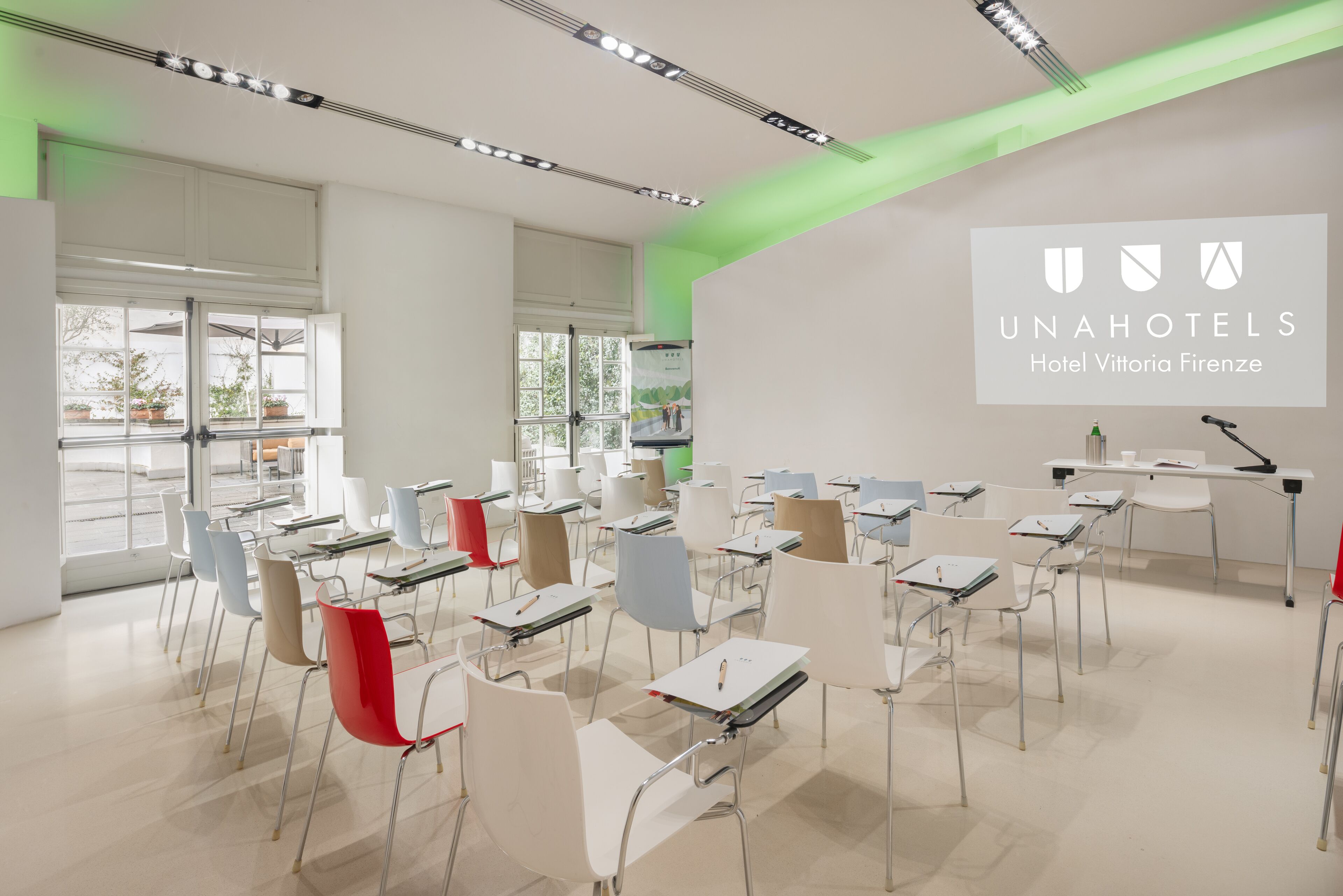 Une salle de classe avec des bureaux et des chaises disposés pour une réunion ou un cours.