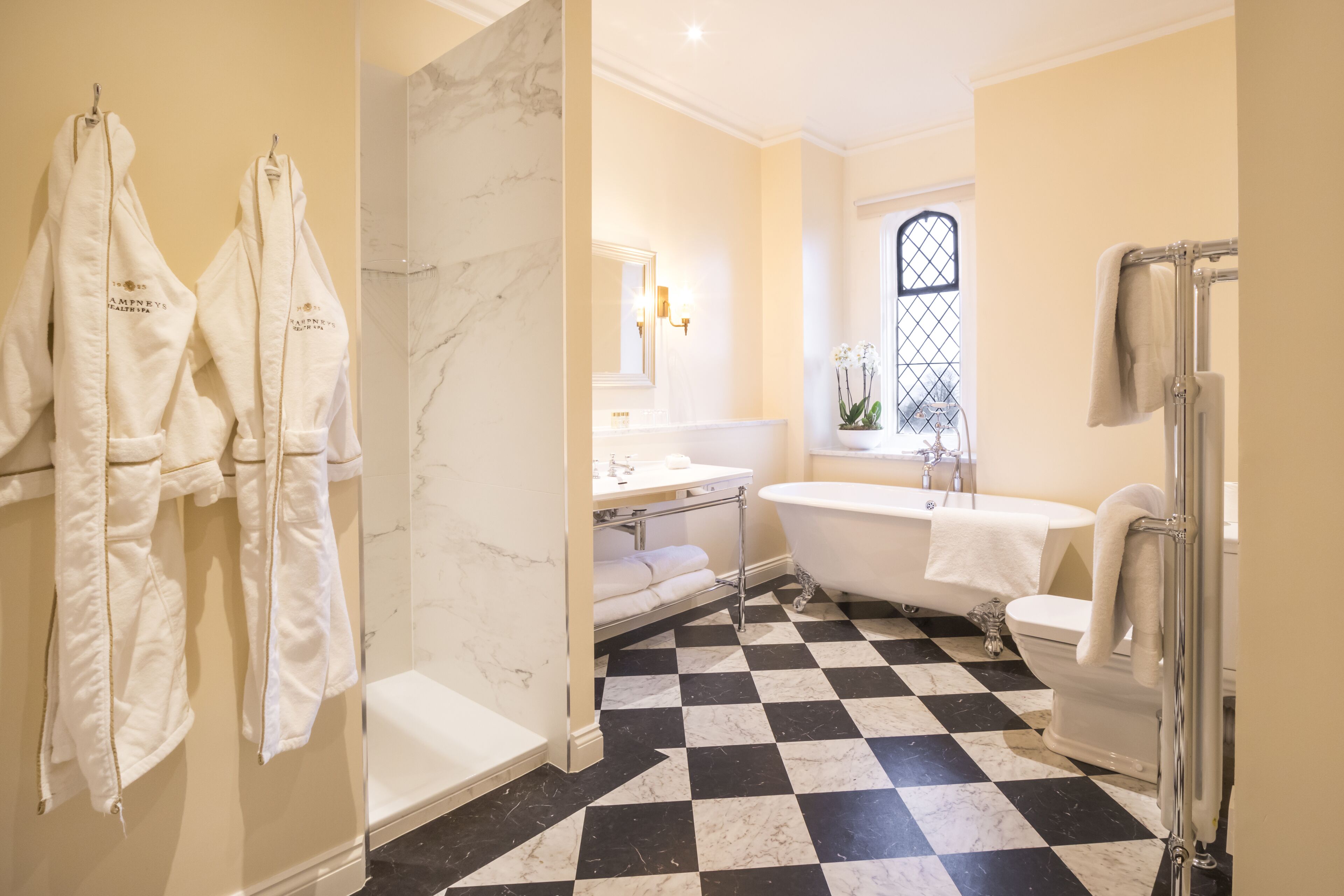 Une salle de bain avec un carrelage à motifs géométriques, une baignoire, des toilettes et un lavabo.