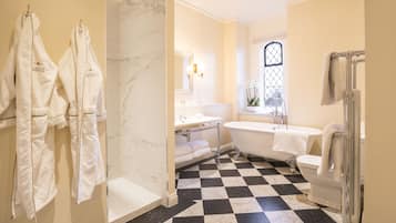 Une salle de bain avec un carrelage à motifs géométriques, une baignoire, des toilettes et un lavabo.