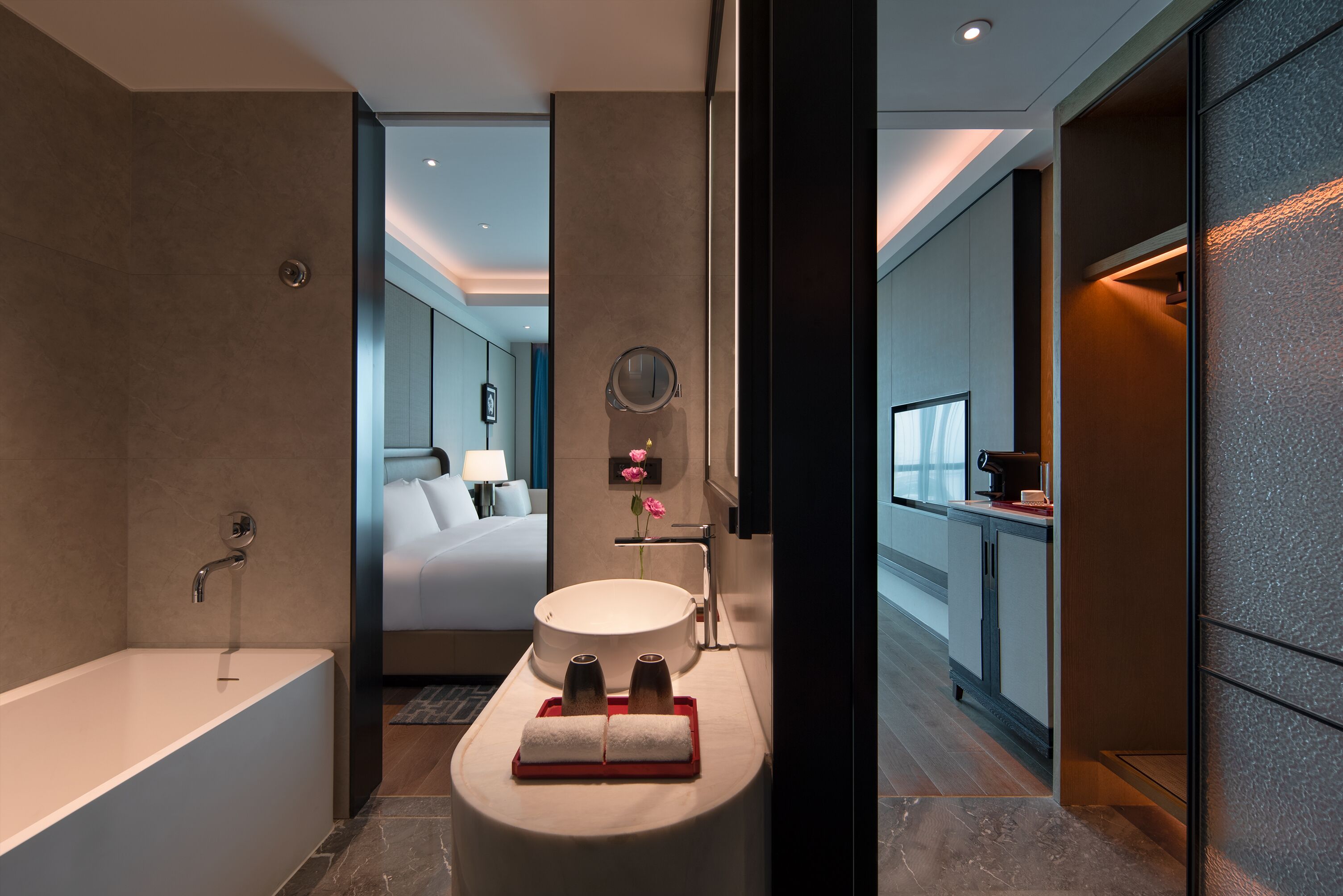 Een moderne badkamer met een badkuip, een rond wastafel en een wastafelmeubel met spiegel.