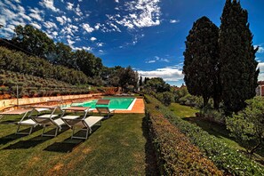 Una piscina al aire libre de temporada, sillones reclinables de piscina