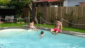 Una piscina al aire libre de temporada, sombrillas