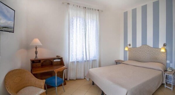 A hotel room with a bed, a desk, a chair, and a window with curtains. - Hotel Sette Archi (Ameglia)